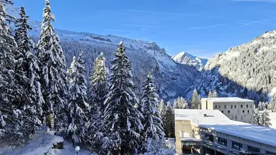 a group of trees covered in snow next to a building at Résidence Betelgeuse - Appartement rénové · Entre pistes et commerces · Balcon MAE-7382 in Flaine