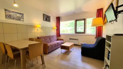 a living room with a table and a couch at Residence De La Foret - Appartement confortable · Proche des pistes · WIFI gratuit et illimité MAE-7386 in Flaine
