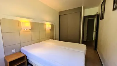 a bedroom with a white bed with lights on the wall at Residence De La Foret - Appartement confortable · Proche des pistes · WIFI gratuit et illimité MAE-7386 in Flaine