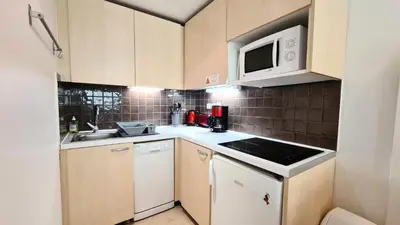 a small kitchen with a sink and a microwave at Residence De La Foret - Appartement confortable · Proche des pistes · WIFI gratuit et illimité MAE-7386 in Flaine