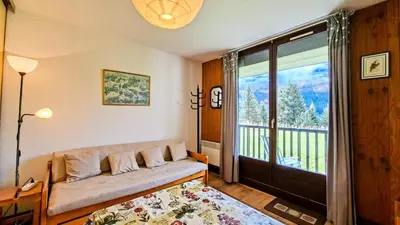 a living room with a couch and a large window at Résidence Sagittaire - Studio confortable avec balcon · Centre station MAE-7388 in Flaine