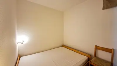 a small room with a small bed and a light at Résidence Sagittaire - Studio confortable avec balcon · Centre station MAE-7388 in Flaine