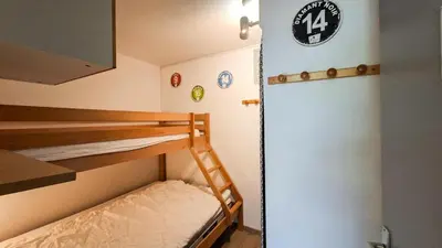a bunk bed room with two bunk beds and a door at Résidence Sagittaire - Studio entièrement rénové avec cabine · Centre station · Balcon MAE-7390 in Flaine