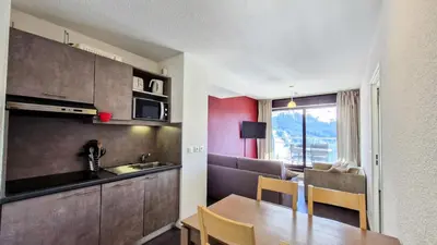 a kitchen and dining room with a table and a kitchen and a couch at Résidence Les Terrasses De Veret - Appartement confortable · Au pied des pistes · Piscine · Spa · Parking inclus MAE-7391 in Flaine