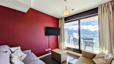 a living room with a couch and a large window at Résidence Les Terrasses De Veret - Appartement confortable · Au pied des pistes · Piscine · Spa · Parking inclus MAE-7391 in Flaine
