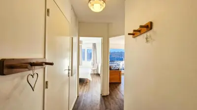 a building on a hill with trees and mountains at Résidence Les Pleiades - Appartement lumineux · Centre station · Balcon MAE-7393 in Flaine