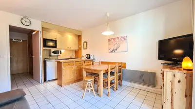 a kitchen with a table and a kitchen with a television at Résidence Castor - Studio rénové avec casier à ski · Proche des pistes · Balcon MAE-7394 in Flaine
