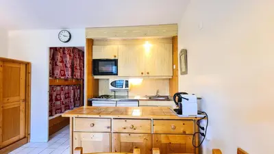 a kitchen with wooden cabinets and a counter top at Résidence Castor - Studio rénové avec casier à ski · Proche des pistes · Balcon MAE-7394 in Flaine