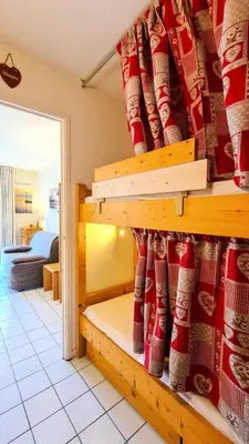a room with a bed with red socks on the wall at Résidence Castor - Studio rénové avec casier à ski · Proche des pistes · Balcon MAE-7394 in Flaine