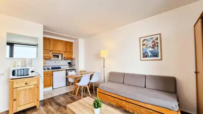 a living room with a couch and a kitchen at Résidence Vega - Studio lumineux · Proche des pistes et des commerces · Balcon MAE-7400 in Flaine