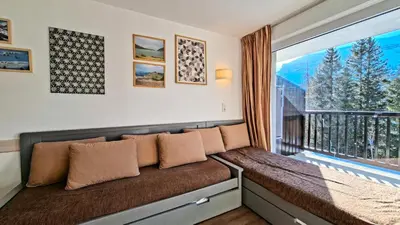 a couch in a room with a large window at Résidence Les Pleiades - Appartement confortable · Centre station · Parking couvert · Balcon MAE-7401 in Flaine