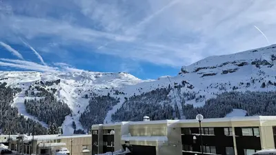 a building with a snow covered mountain in the background at Résidence La Petite Ourse - Studio neuf · Centre station · Balcon MAE-7402 in Flaine