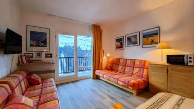 a living room with a couch and a window at Résidence Andromede - Studio lumineux avec casier à ski · Proche des pistes · Balcon MAE-7403 in Flaine