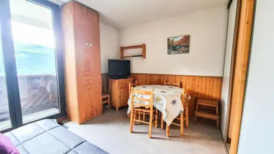 a room with a table with chairs and a television at Résidence Doris - Studio lumineux · Centre station · Balcon MAE-7404 in Flaine