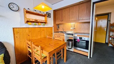 a kitchen with a wooden table and a clock on the wall at Résidence Andromede - Studio spacieux · Proche des pistes MAE-7407 in Flaine