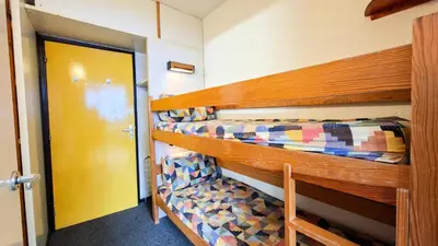 a room with two bunk beds and a yellow door at Résidence Andromede - Studio spacieux · Proche des pistes MAE-7407 in Flaine