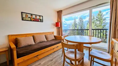 a kitchen and a living room with a table at Résidence Les Pleiades - Appartement lumineux · Centre station · Parking couvert · Balcon MAE-7409 in Flaine