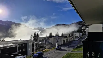 a view of a city with clouds in the mountains at Résidence Gemeaux - Studio confortable · Centre station · Balcon MAE-7410 in Flaine