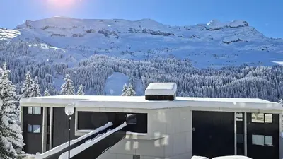 a building with a snow covered mountain in the background at Résidence Andromede - Studio rénové · Proche des pistes · Balcon · Casier à ski MAE-7411 in Flaine
