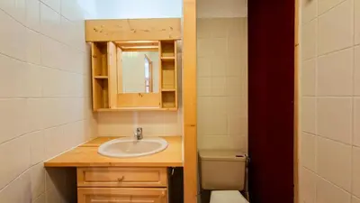 a bathroom with a sink and a mirror and a toilet at Résidence Arche - Studio confortable · Centre station · Terrasse MAE-7414 in Flaine