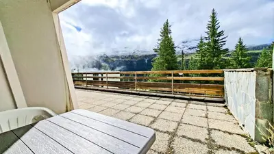 a balcony with a bench and a view of a mountain at Résidence Arche - Studio confortable · Centre station · Terrasse MAE-7414 in Flaine
