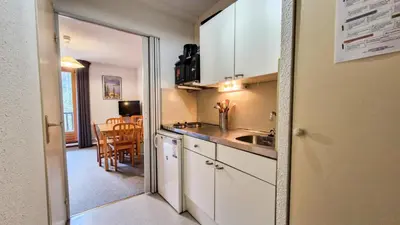 a small kitchen with a sink and a table at Résidence Pollux - Studio confortable avec cabine · Proche des pistes et des commerces · Balcon MAE-7415 in Flaine