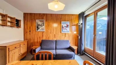a living room with a blue couch and a table at Résidence Pollux - Studio confortable avec cabine · Proche des pistes et des commerces · Balcon MAE-7415 in Flaine