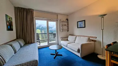 a living room with a couch and a balcony at Résidence Andromede - Studio lumineux · Proche des pistes · Balcon avec jolie vue MAE-7419 in Flaine
