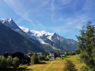 a village with snow covered mountains in the background at Chalet Hôtel La Sapinière in Chamonix-Mont-Blanc