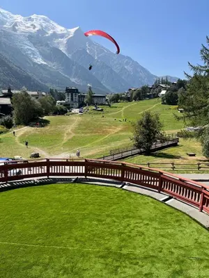 a kite flying over a field with a wooden fence at Chalet Hôtel La Sapinière in Chamonix-Mont-Blanc