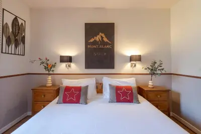 a bedroom with a white bed with two pillows at Chalet Hôtel La Sapinière in Chamonix-Mont-Blanc