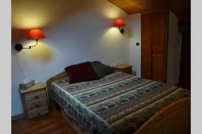 a bedroom with a bed with two lamps on the wall at Le Rustica, 3 rooms, 3 stars, 6 people in Les Houches