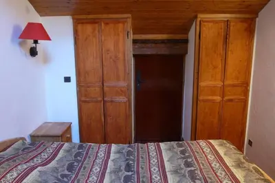 a bedroom with a bed and a wooden closet at Le Rustica, 3 rooms, 3 stars, 6 people in Les Houches