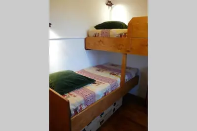 two bunk beds are in a room with a wall at Le Rustica, 3 rooms, 3 stars, 6 people in Les Houches