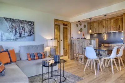 a living room and kitchen with a couch and a table at Appartement Eskimo in Megève