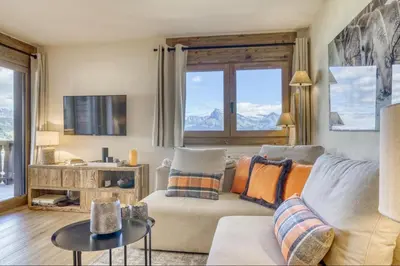 a living room with a couch and a tv at Appartement Eskimo in Megève