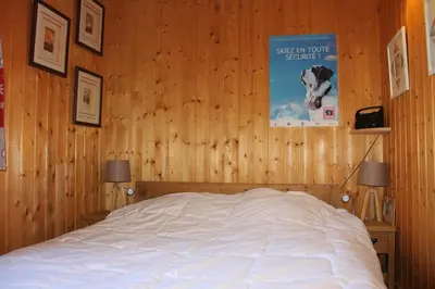 a bedroom with a bed in a wooden wall at Comfortable Apartment With Terrace In Chamonix in Chamonix-Mont-Blanc