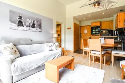 a living room with a couch and a table at 1-bed apartment in 5* Residence with mountain views, ski in, ski out in Flaine