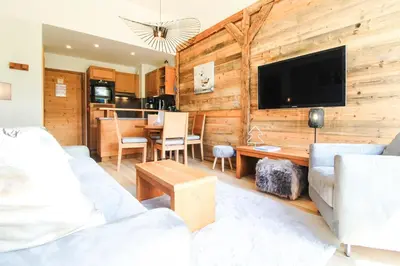 a living room with a wooden wall with a tv at 1-bed apartment in 5* Residence with mountain views, ski in, ski out in Flaine