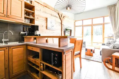 a kitchen with wooden cabinets and a counter top at 1-bed apartment in 5* Residence with mountain views, ski in, ski out in Flaine