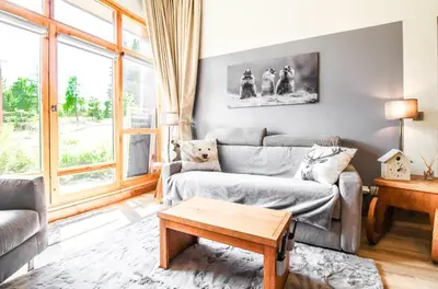 a living room with a couch and a table at 1-bed apartment in 5* Residence with mountain views, ski in, ski out in Flaine
