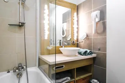 a bathroom with a tub and a sink and a shower at 1-bed apartment in 5* Residence with mountain views, ski in, ski out in Flaine