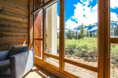 a room with a window with a couch and a view at 1-bed apartment in 5* Residence with mountain views, ski in, ski out in Flaine