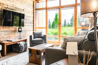 a living room with a couch and a tv at 1-bed apartment in 5* Residence with mountain views, ski in, ski out in Flaine