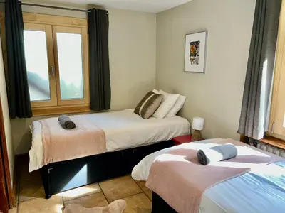 a room with two beds and a window at 3 Bedrooms, Whole floor, New Kitchen, Town Centre in Chamonix-Mont-Blanc