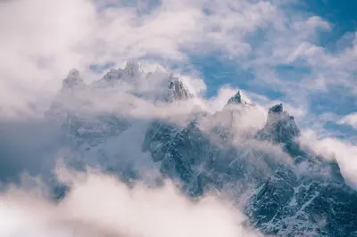 a mountain covered in clouds in the sky at Cosmiques Hotel - Centre Chamonix in Chamonix-Mont-Blanc