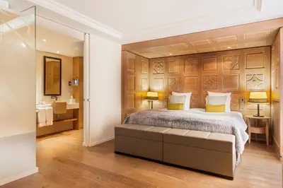 a bedroom with a large bed with a wooden headboard at Hôtel Mont-Blanc Chamonix in Chamonix-Mont-Blanc