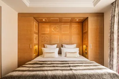 a bedroom with a bed with a wooden headboard at Hôtel Mont-Blanc Chamonix in Chamonix-Mont-Blanc