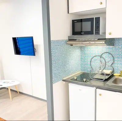 a kitchen with white cabinets and a microwave at Cosy Nest Near Center Chamonix in Chamonix-Mont-Blanc