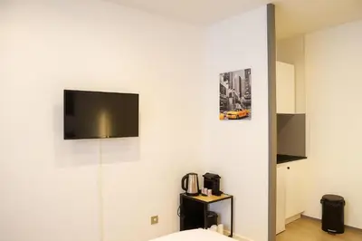 a room with a tv on a white wall at Cosy Nest Near Center Chamonix in Chamonix-Mont-Blanc